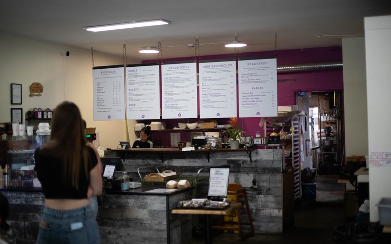 Inside The Fig café in downtown Vernon with menu boards and a customer ordering