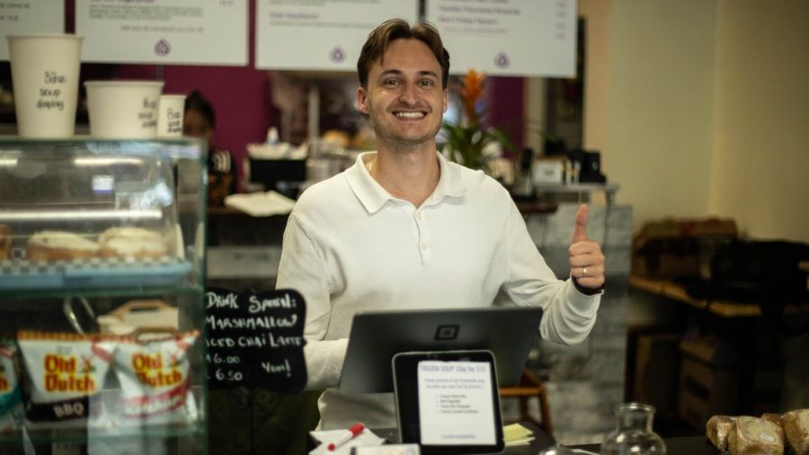 The Fig owner David Scarlatescu smiling behind the counter of his downtown Vernon café