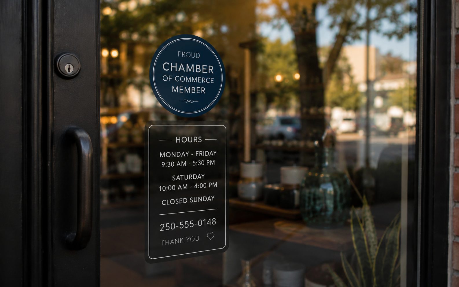 Vernon shop door with a Chamber of Commerce member decal and the business hours and phone