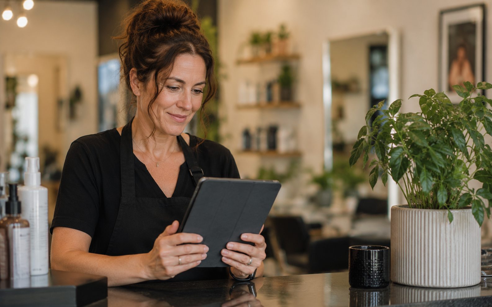 Vernon salon owner reading new Google reviews on a tablet at the front counter